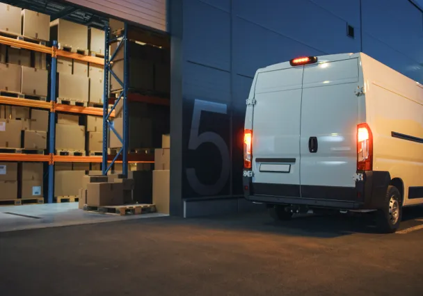 camionnette de livraison garée à l'extérieur d'un entrepôt pour une livraison de nuit