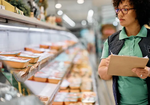 femme qui réassortit des produits alimentaires