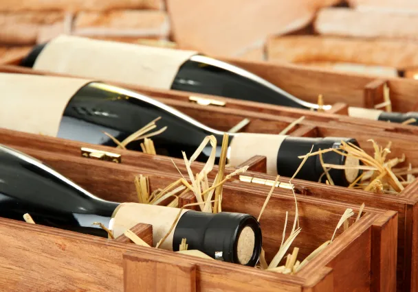 Bouteilles de vin calées dans des caisses en bois garnies de paille