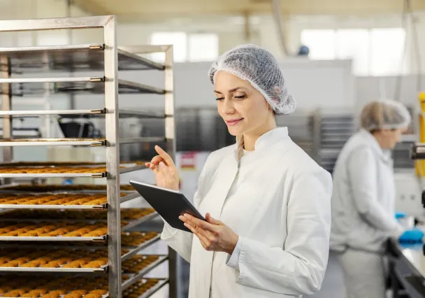 Responsable qualité vérifiant sur tablette un chariot de production en atelier agroalimentaire