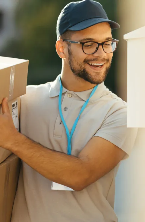 Un livreur souriant, casquette et lunettes, un colis sous le bras