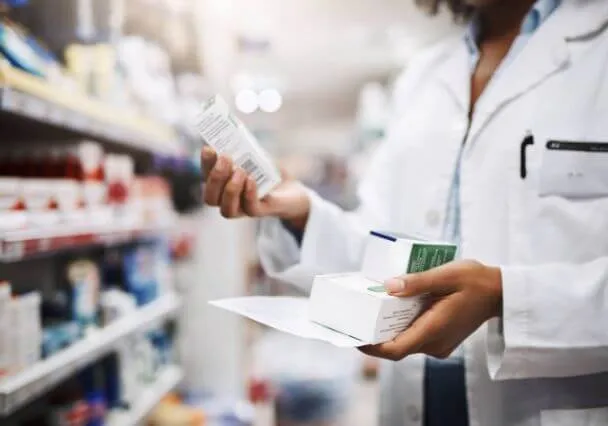 Pharmacienne préparant une commande de médicaments derrière le comptoir