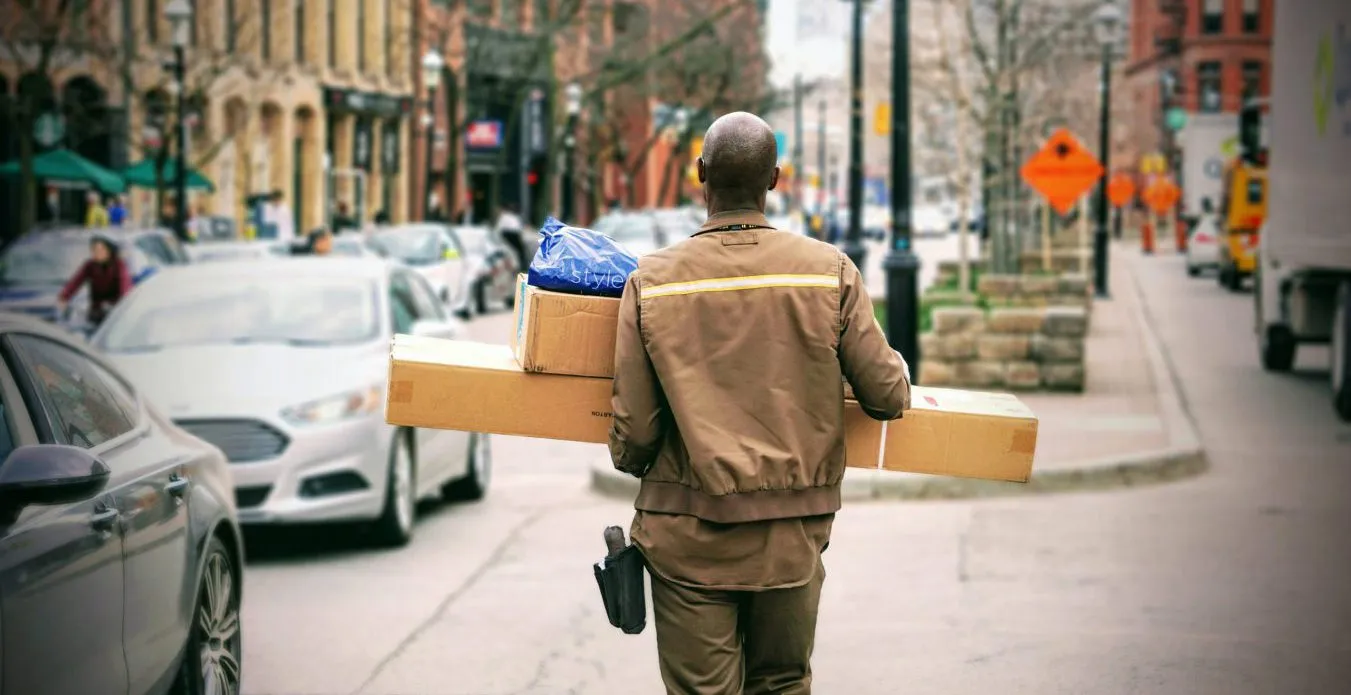 livreur qui transporte des colis en rue