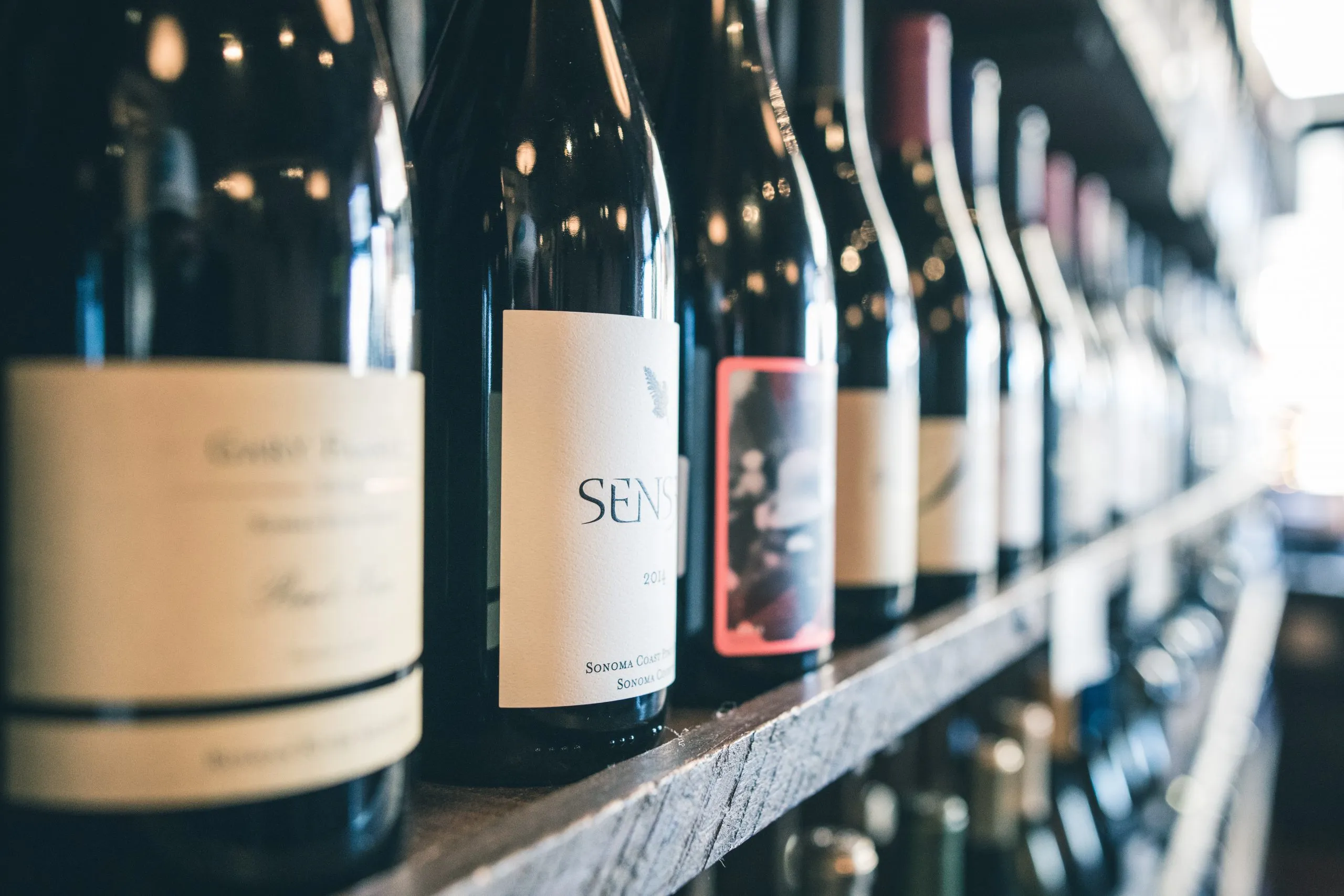 bouteille de vin avec étiquettes sur une étagère