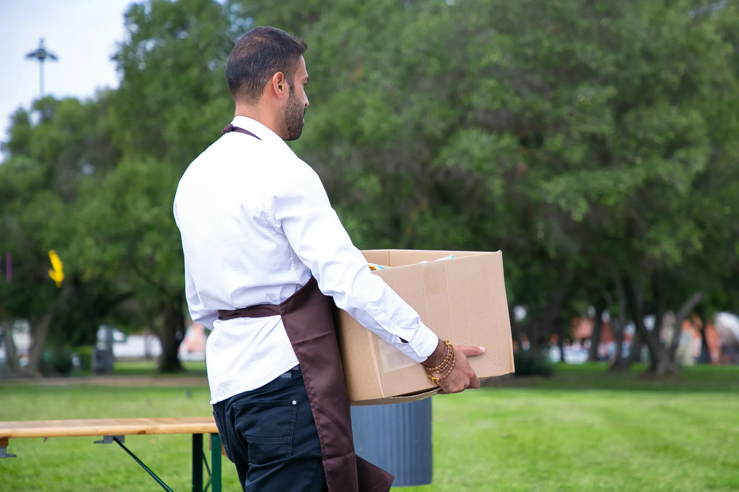 employé avec tablier portant une caisse pendant un événement