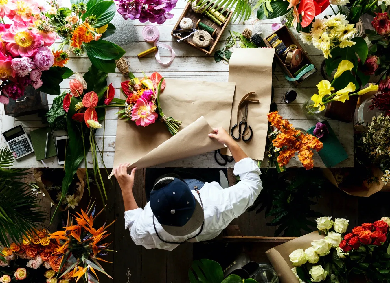 fleuriste qui emballe un bouquet