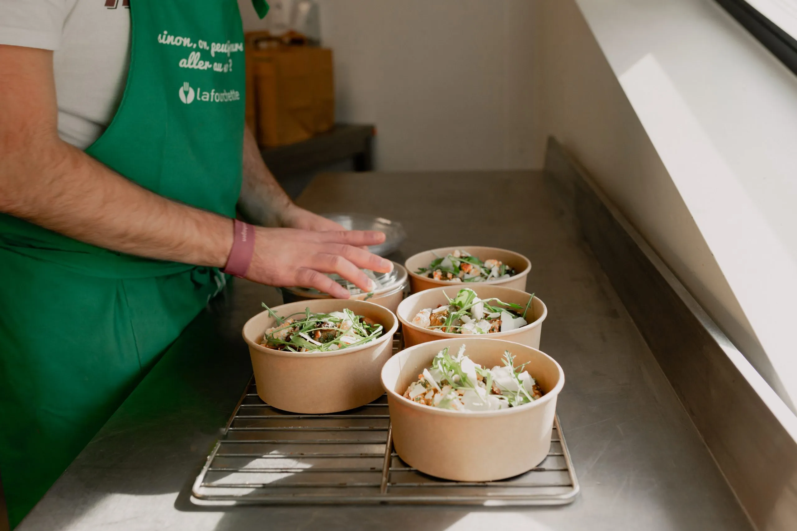 un cuisinier qui ferment des bowl pour être livrés par Shippr