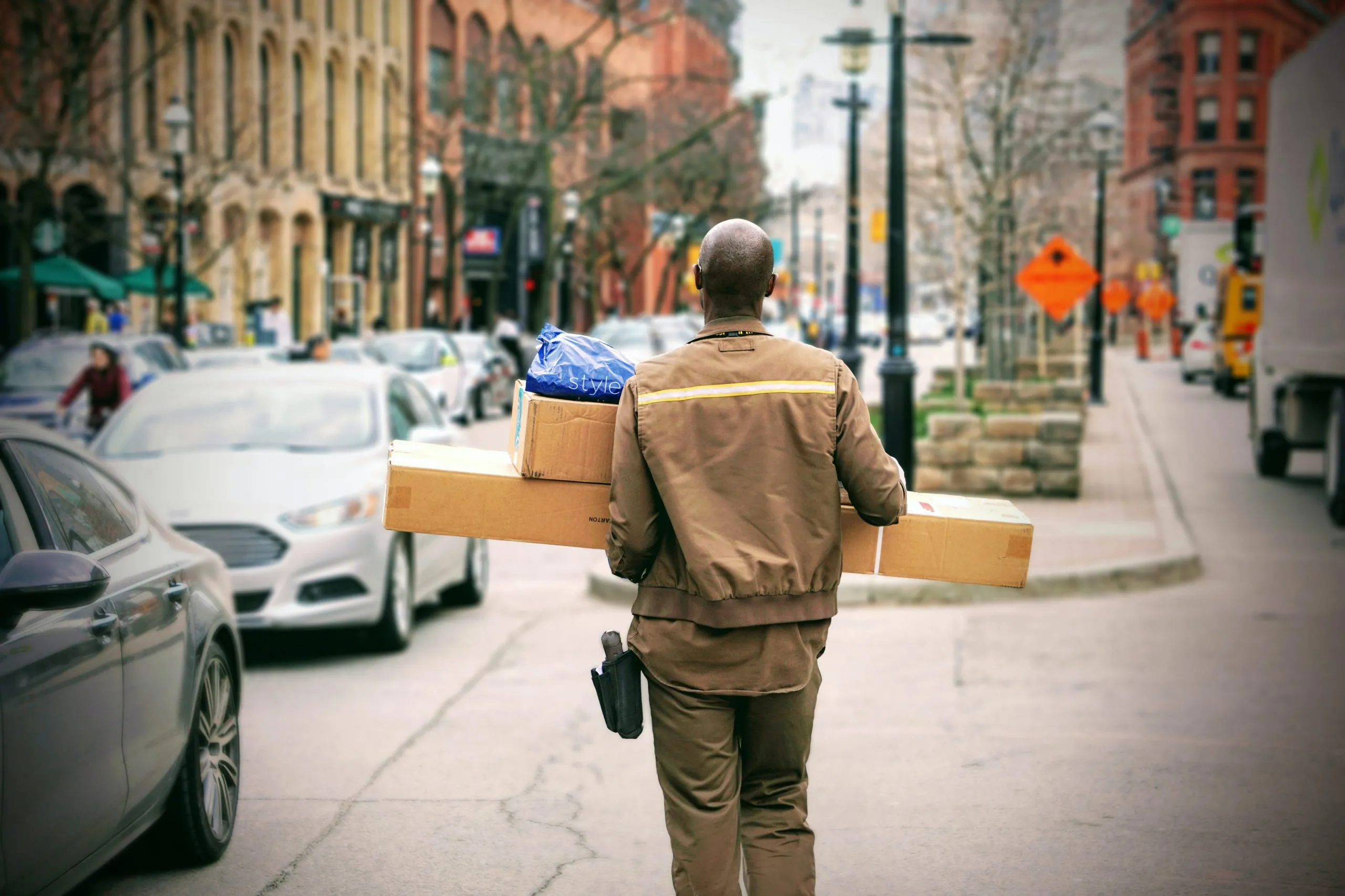 livreur qui transporte des colis en rue