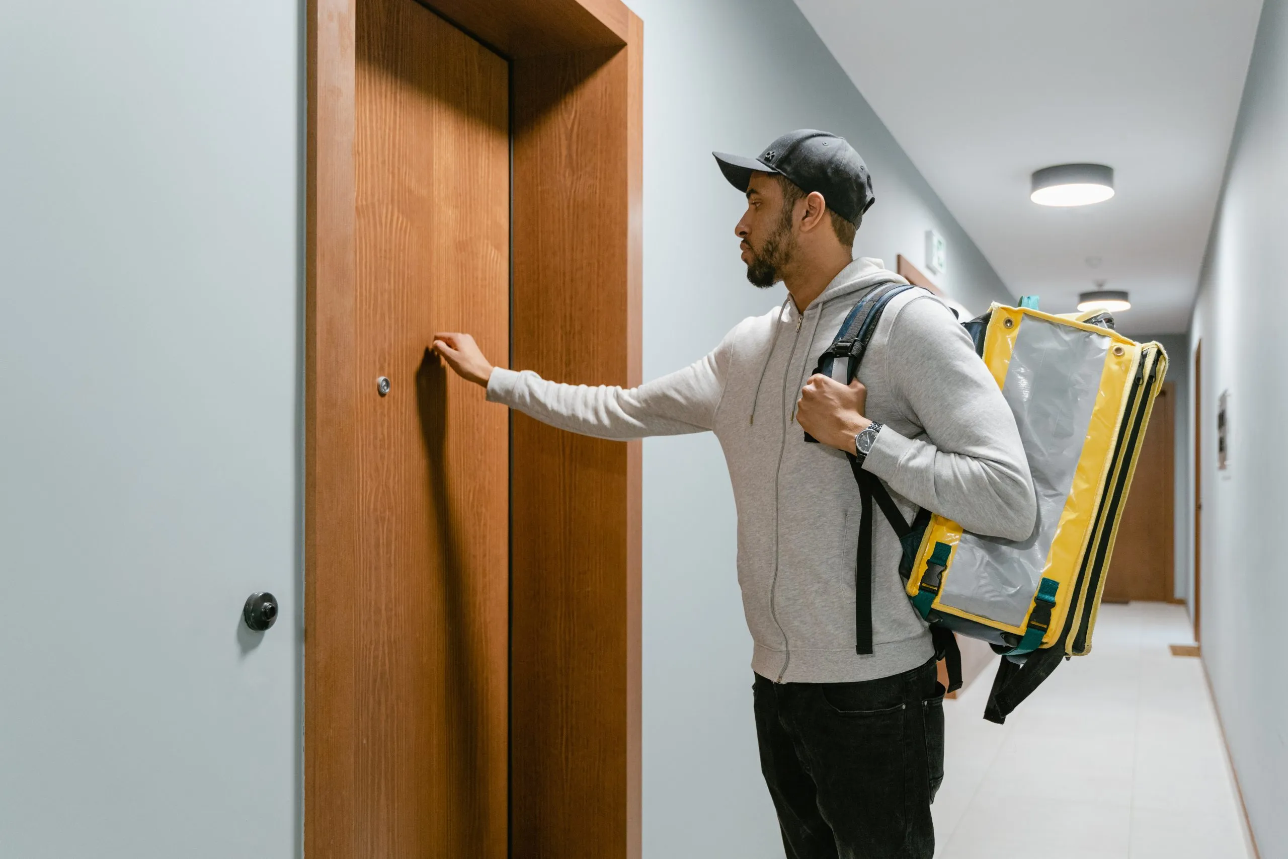 Livreur indépendant qui frappe à une porte 