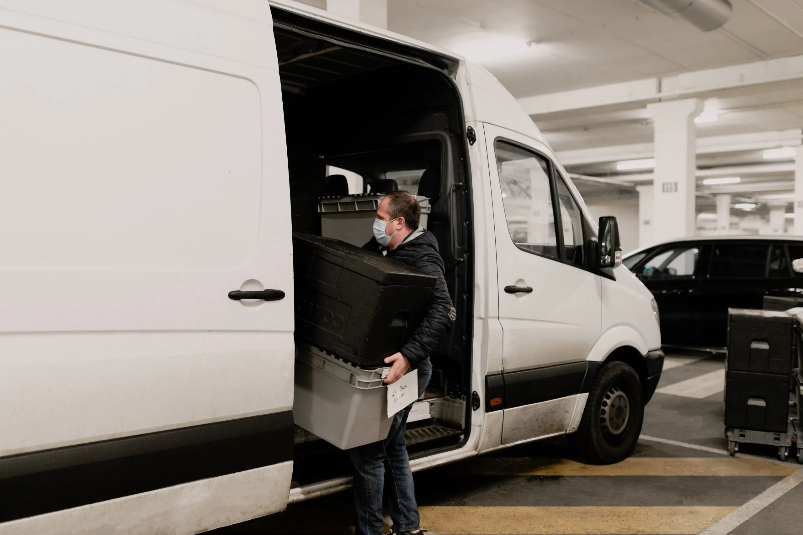 Livreur partenaire shippr mettant des caisses dans un camion blanc