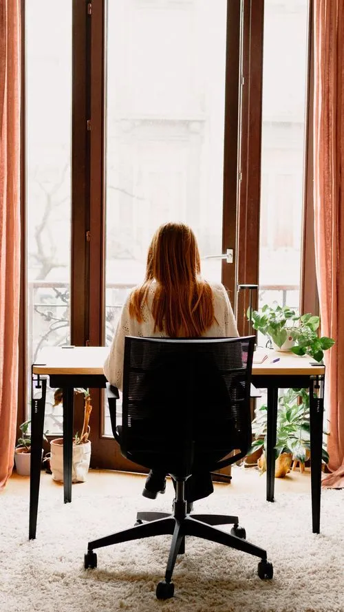 Femme de dos assise à son bureau